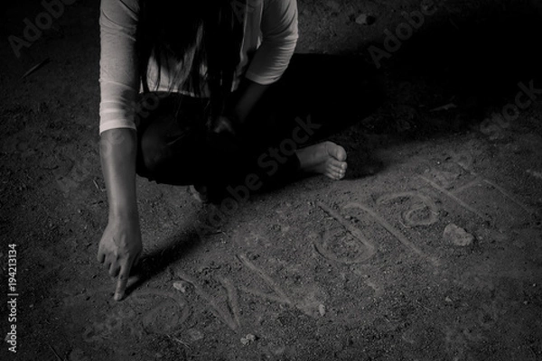 Fototapeta Give me support. Poor depressed woman folding her legs and sitting on the floor while writing help me
