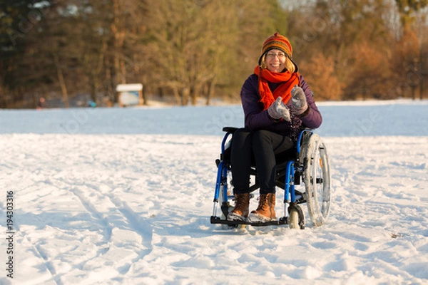 Obraz happy woman on wheelchair in the snow