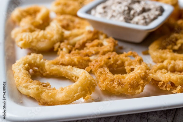 Fototapeta Fried Crispy Calamari Squid Rings with Tartar Sauce and Lemon.