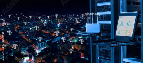 Fototapeta Bezprzewodowe centrum zarządzania i koncepcja telekomunikacyjna, centrum danych z bezprzewodowym urządzeniem dostępowym, monitor kvm i serwery na stojaku i tle nocnego miasta z łącznością ikon wifi