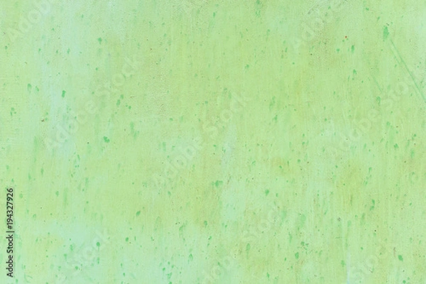 Fototapeta Textured metal surface carelessly colored green paint and faded in the sun in pale gray with rusty specks.