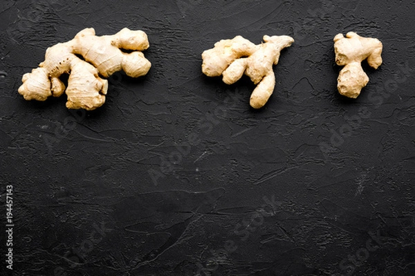 Fototapeta Whole ginger roots on black background top view space for text