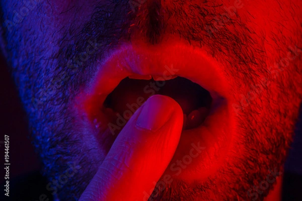 Obraz Macro close up on man with seductive facial expression holding finger on mouth