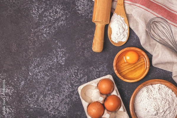 Fototapeta Ingredients for baking  - flour, wooden spoon, rolling pin, eggs