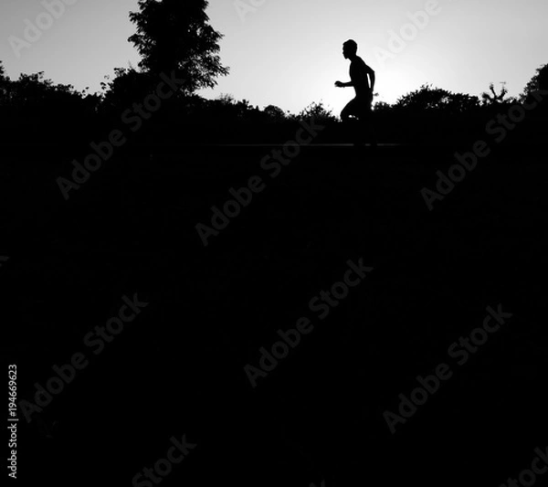 Fototapeta Close up the runner start from run on railroad tracks with dramatic tone, Sunset running in the evening