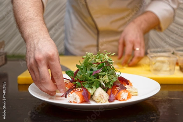 Fototapeta Chef is cooking salmon roll appetizer
