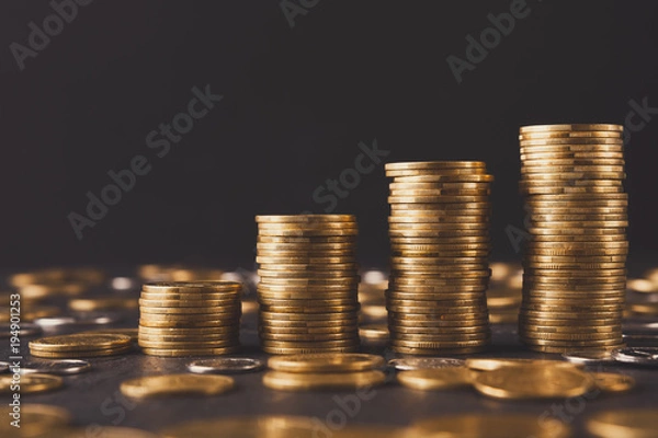 Fototapeta Increasing columns of gold coins on table
