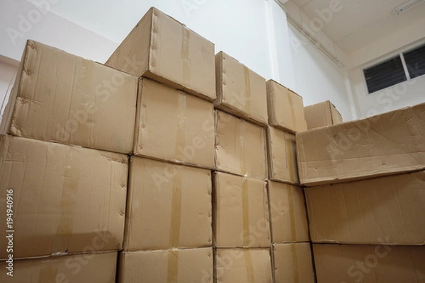 Fototapeta Corrugated Cardboard storage boxes stacked in warehouse of small factory