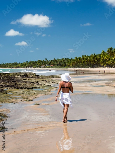 Obraz attractive woman walking along beach with view on a summer day