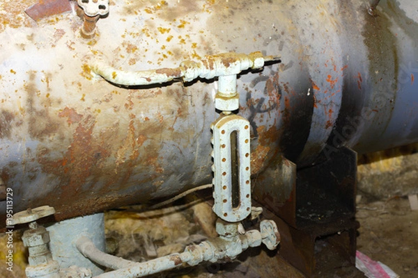 Obraz Old and rusty shut-off valve and taps from equipment at an abandoned and destroyed factory amid chaos. Destruction and vandalism. Ukraine.