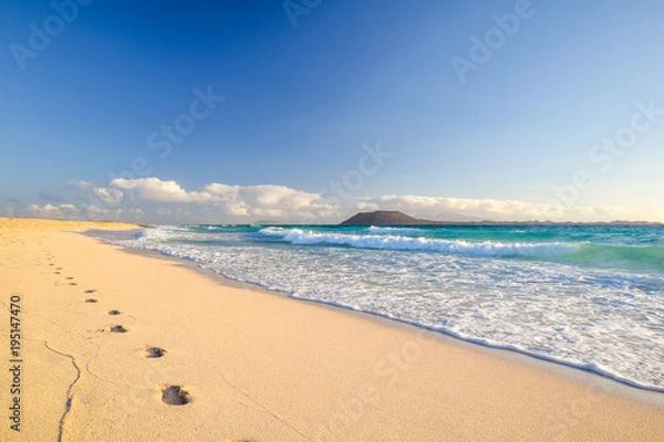 Obraz Oszałamiający poranny widok na wyspy Lobos i Lanzarote z plaży Corralejo (Grandes Playas de Corralejo) na Fuerteventurze, Wyspy Kanaryjskie, Hiszpania, Europa. Piękne ślady na piasku.