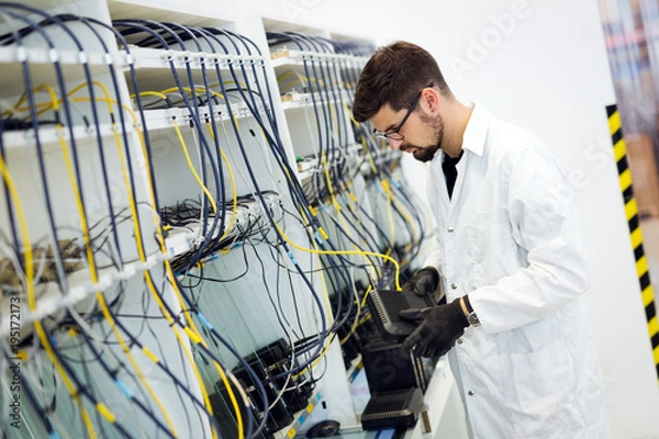 Obraz Picture of network technician testing modems in factory