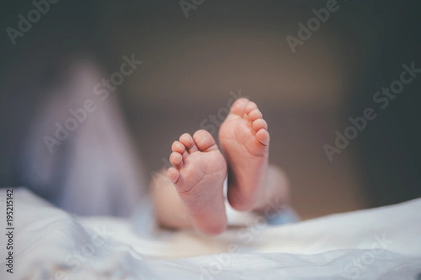 Obraz tiny feet of a newborn baby in focus during the diaper changes