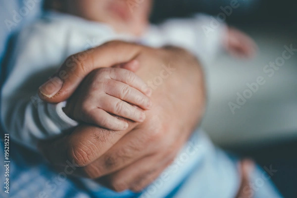 Obraz small hand of a newborn supported by the big hand of his father