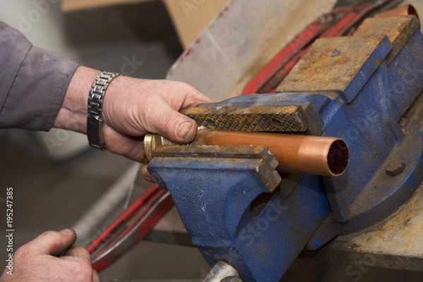 Obraz copper pipe in a vice ready for threading