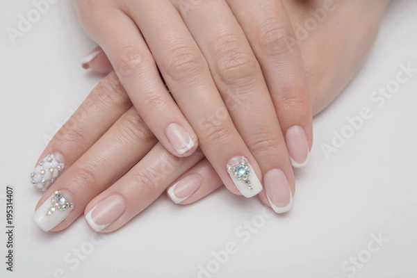 Fototapeta Light manicure in light on a white background.