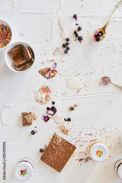 Obraz Dirty table after cooking and eating ice cream: drops, sprinkles, berries. The concept of mess, dirty dishes.