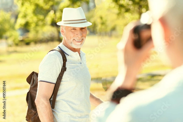 Fototapeta Happy moments. Cheerful delighted nice man smiling and looking into the camera while posing for a photo