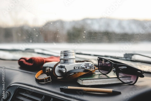 Fototapeta Notebook, glasses and film camera on the dashboard