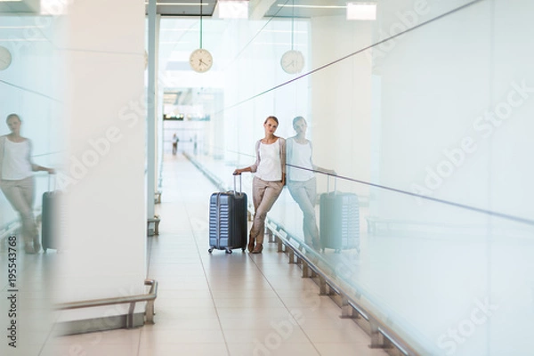 Fototapeta Young female passenger at the airport, about to check-in