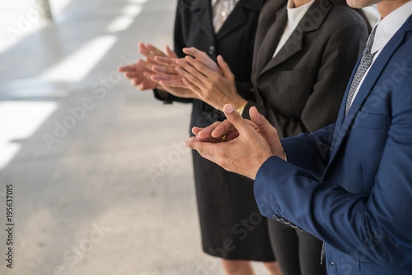 Fototapeta business man and business woman clap their hands to congratulate the signing of an agreement or contract between their companies. success, dealing, greeting and partner concept.