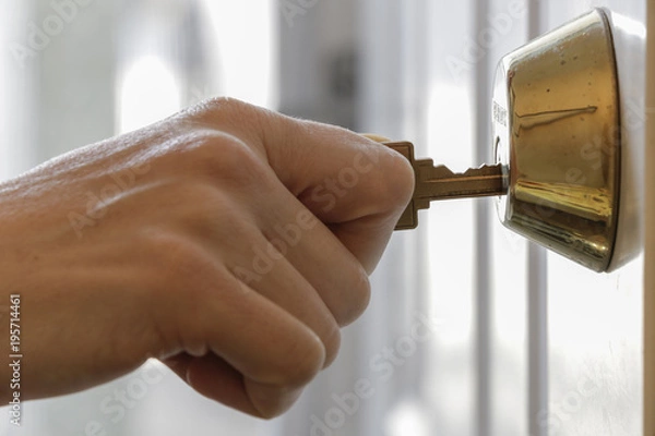 Obraz Hand Holding Key in Dead Bolt Lock