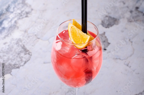 Obraz Classic Italian Aperol Spritz cocktail consisting of prosecco, aperitif and soda water with orange slice fresh fruit in wineglass on background. Exotic red summer drink. Bar alcohol menu