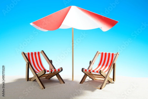 Fototapeta Two chaise longue under an umbrella on the sandy beach, sky with copy space