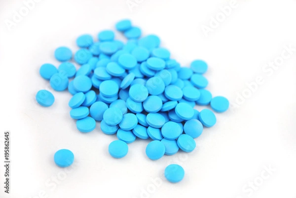 Obraz Bright blue tablets close-up on white background