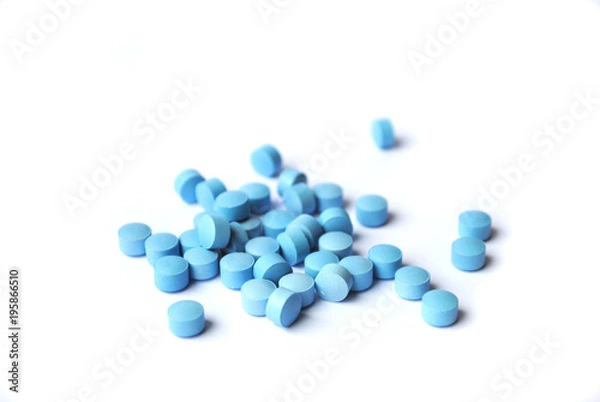 Obraz Small bright blue tablets closeup on white background