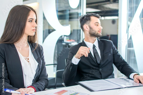 Obraz Business people sitting around table at meeting.