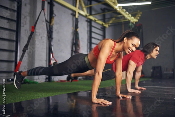 Obraz Man and woman working out in gym