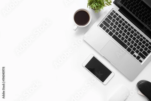 Fototapeta White office desk table with smartphone, laptop computer, cup of coffee and supplies. Top view with copy space, flat lay.