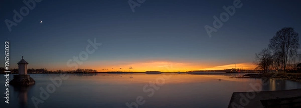 Obraz panorama with a little lighthouse in a lake during sunset