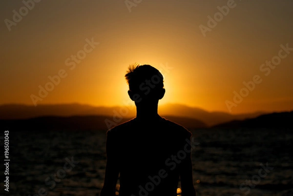 Fototapeta Fascination of silhouette of young boy on sunset