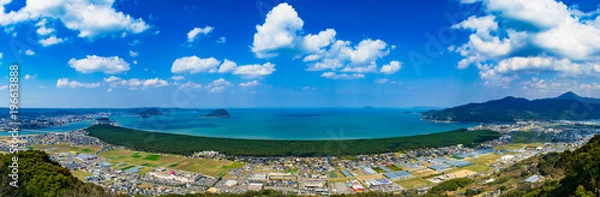 Fototapeta 鏡山展望台から見る「虹の松原」虹の弧のように連なる緑の松原と唐津湾の青い海が美しい絶景 松原の西端には唐津城が見える