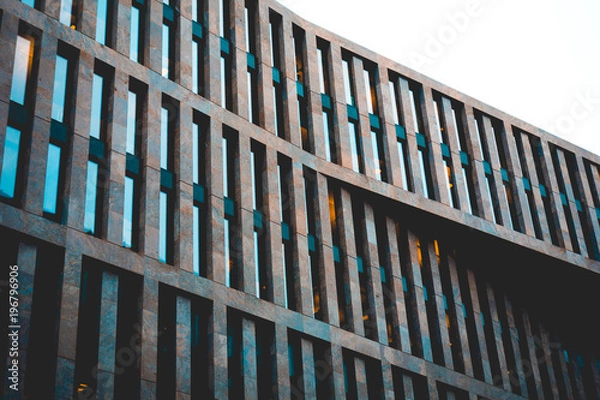 Fototapeta futuristic office building facade with some lights inside