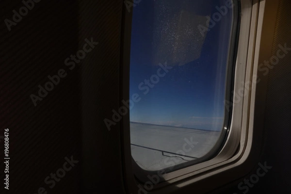 Fototapeta Aicraft window and sky from inside cabin economy class