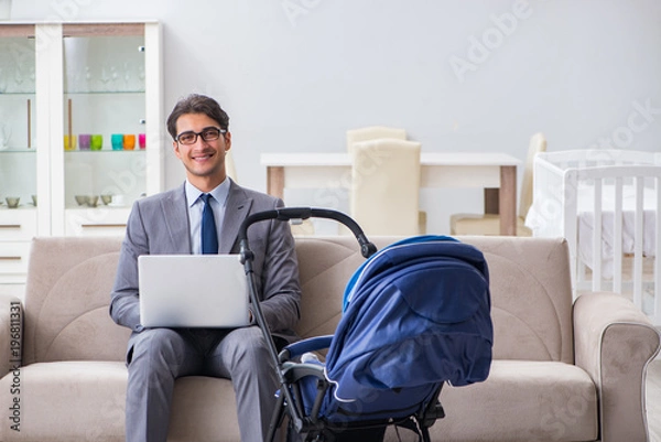 Fototapeta Businessman looking after newborn baby at home and teleworking