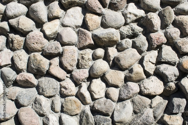 Fototapeta Texture laid out of stone, a wall made of stones on a cement solution