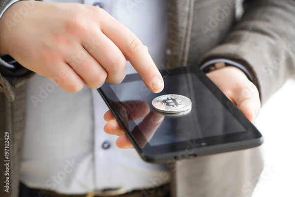 Fototapeta Hand holding smart phone with bitcoin concept on screen.