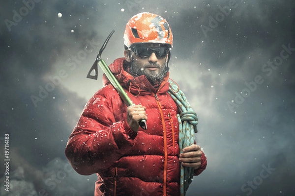 Obraz Climber reaching the summit. Snow storm.