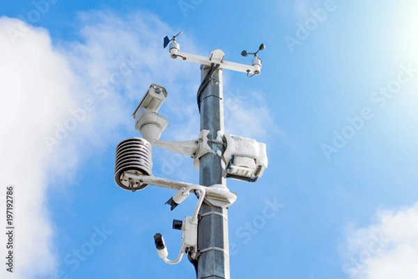 Fototapeta Automatic weather station, with a weather monitoring system and video cameras for observation. Against the background of a blue sky with clouds.