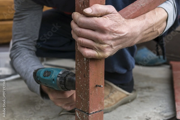 Obraz worker drilling drill metal with red detail