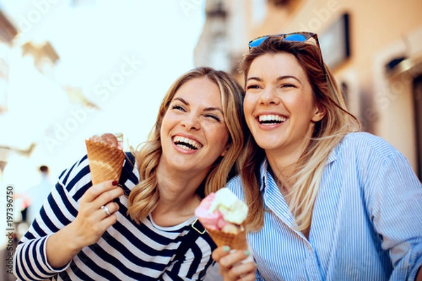 Obraz Dwie młode kobiety śmieją się i trzymają w ręku lody