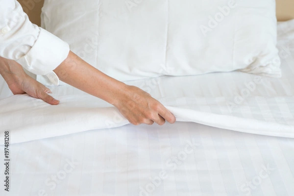 Obraz Female Hand set up white bed sheet in room hotel