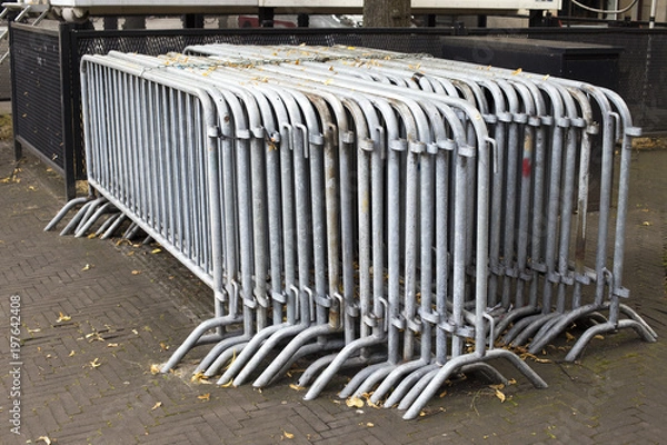 Fototapeta Crowd control barriers and yelow leaves around