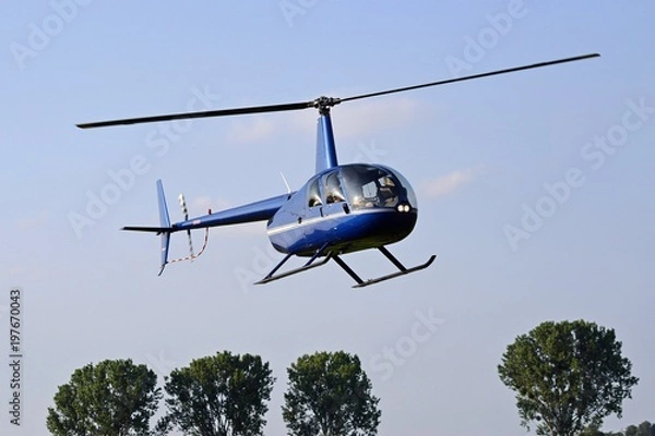 Fototapeta Helikopter latający na niebieskim niebie