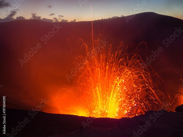 Fototapeta Watching an Erupting Volcano with the Sunset whilst Lava Explodes in Vanuatu, Mt Yassur, Tanna Island