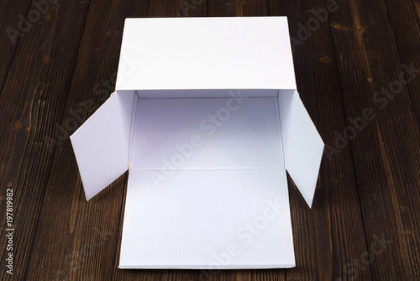 Fototapeta Empty white gift box or tray for mock up on dark wooden table with copy space.